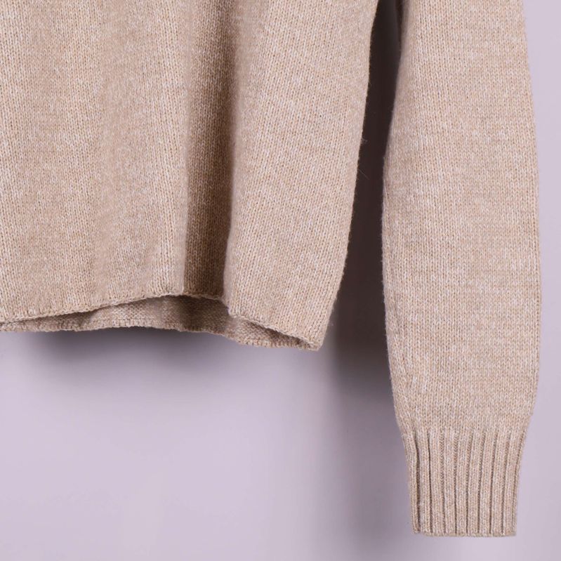 Närbild på nederkant och ärm med ribbade muddar