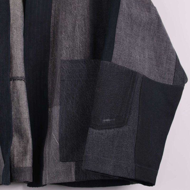 Närbild på kimonoärm och ficka i olika denimtyger
