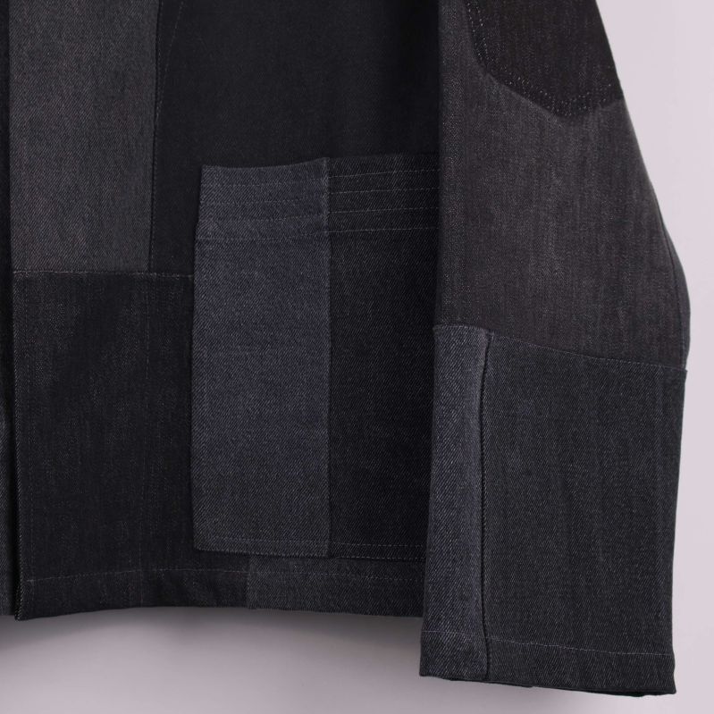 Närbild på ficka och tygstruktur på jackans framsida