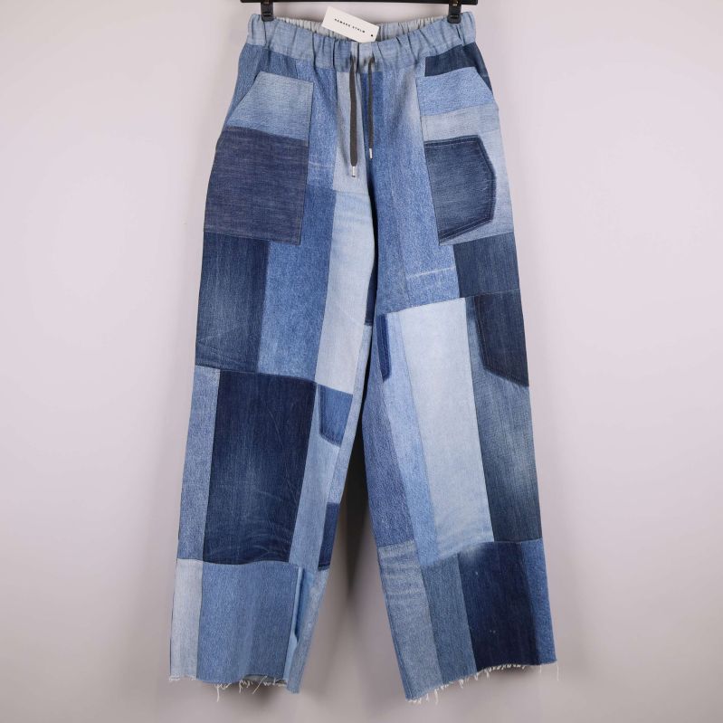 Framsidan av patchworkbyxa i denim med flera nyanser blått