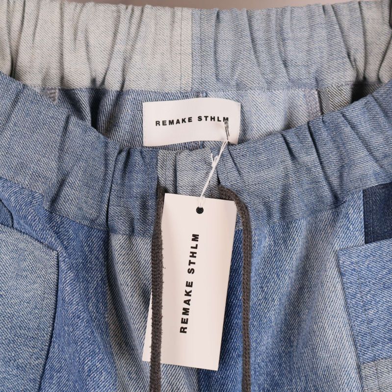 Närbild på resårmidja och etikett i denimbyxa