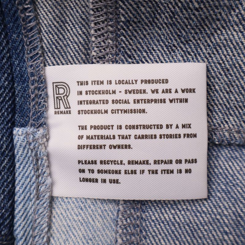 Invändig etikett med engelsk text om plagget och återbruk