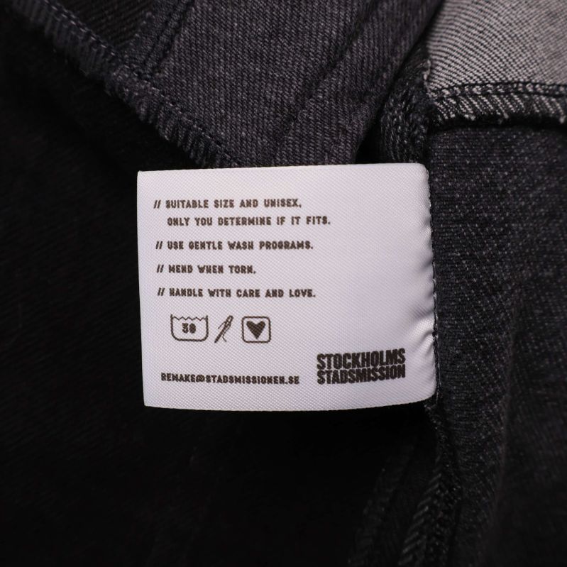 Tvättrådsetikett med symboler och skötselråd på insidan