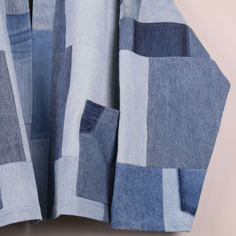 Närbild på fickor och sömmar i patchwork denimjacka