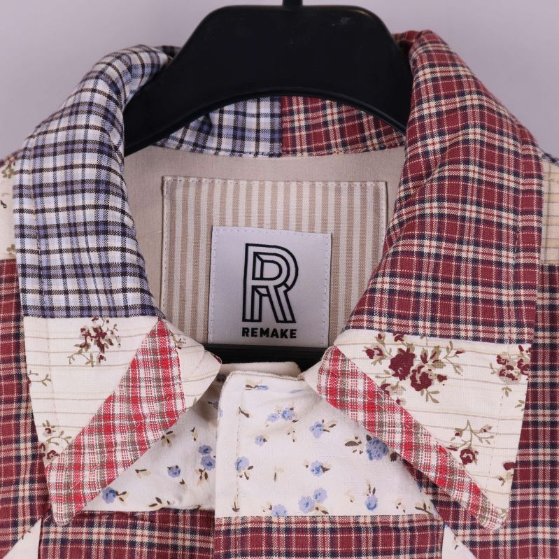 Närbild på kragen med rutigt och blommigt tyg samt Remake-etikett