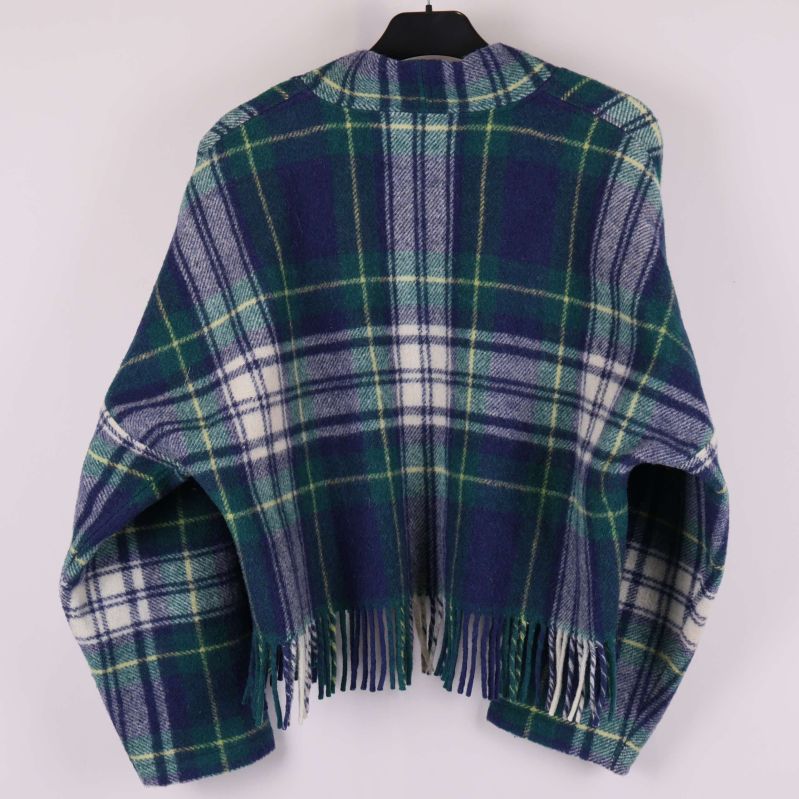 Baksidan av jackan visar rutmönster och fransar nedtill