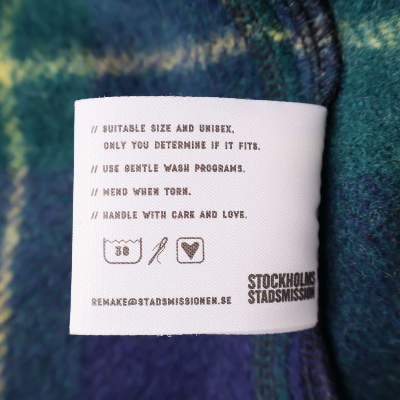 Tvättanvisningar och storleksetikett på insidan av jackan