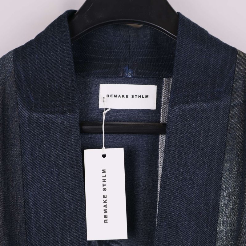 Närbild på denimrockens krage och Remake Sthlm etikett