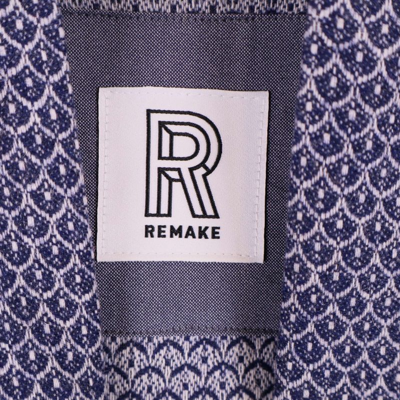Närbild på Remake-logotyp på etikett i jackans hals