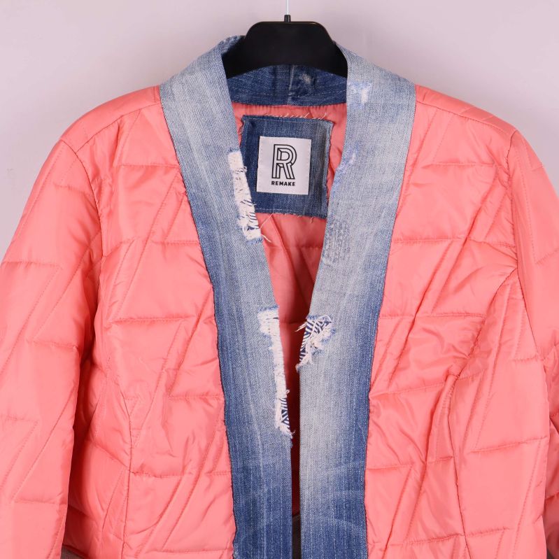 Detaljbild på denimkant och quiltat tyg vid kragen