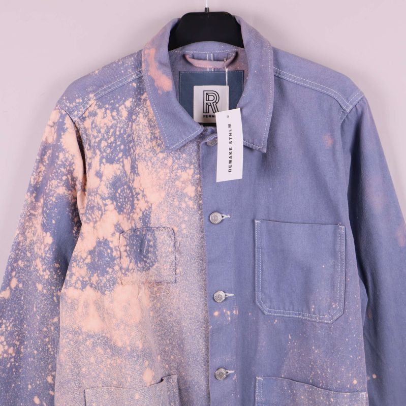 Övre del av jacka med synliga fickor och färgstänk