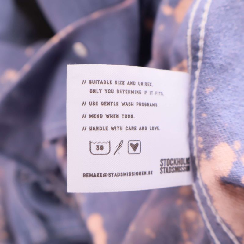 Tvättrådsetikett med symboler och instruktioner på insida