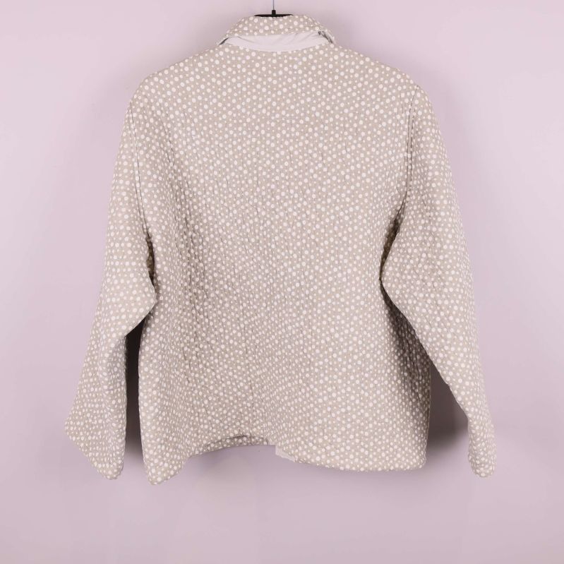 Baksida av beige quiltad jacka med prickar