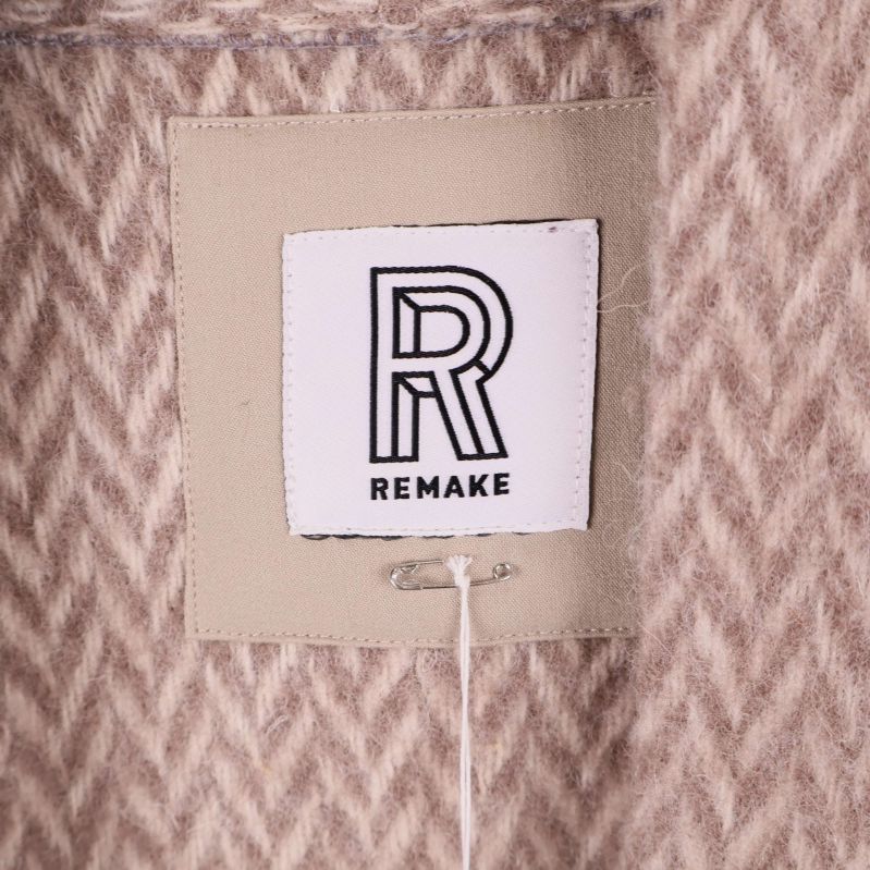 Närbild på tygmärke med Remake-logotyp i kragen