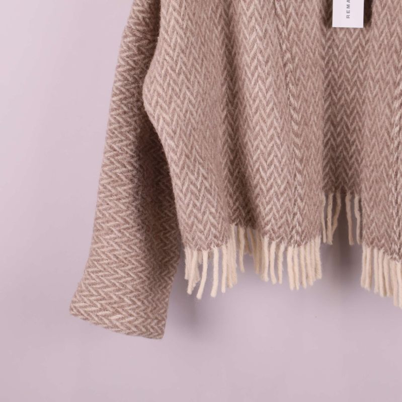 Närbild på jackans fransade nederkant och ärm