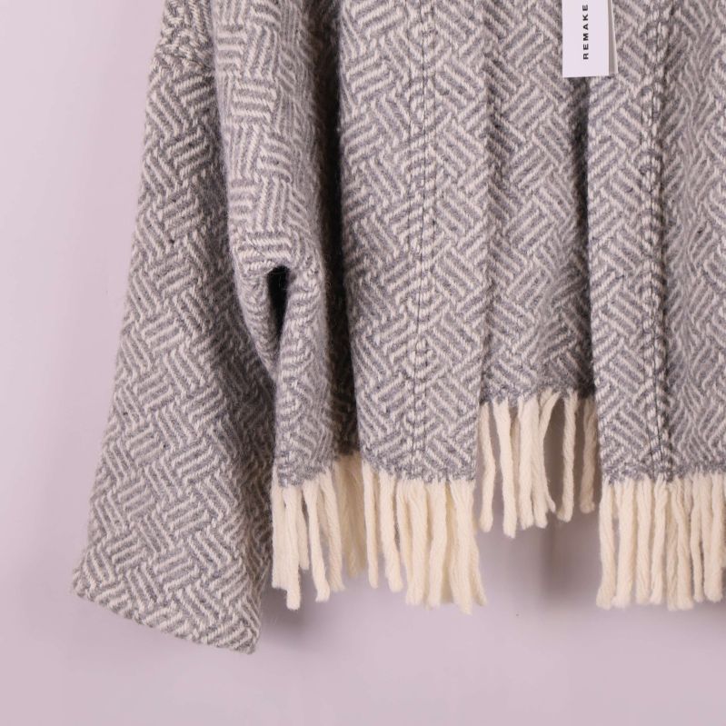 Närbild på jackans ärm och franskant längs nederdelen