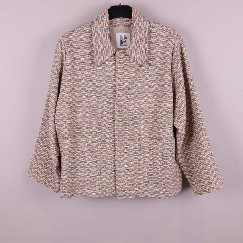 Jacka i vågmönstrat tyg upphängd på galge