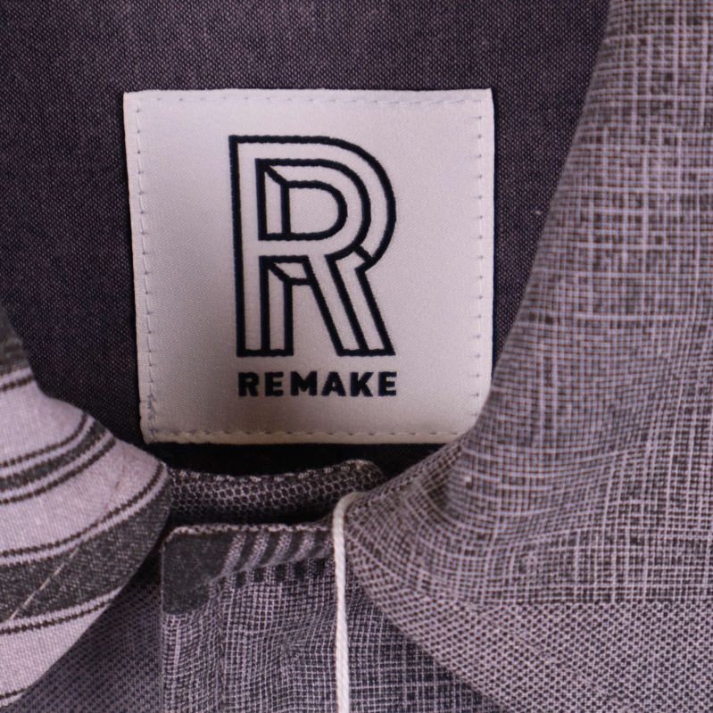 Närbild av Remake-logotyp på jackans etikett