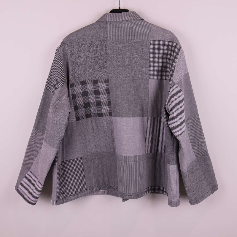 Baksidan av grå patchwork jacka syns tydligt