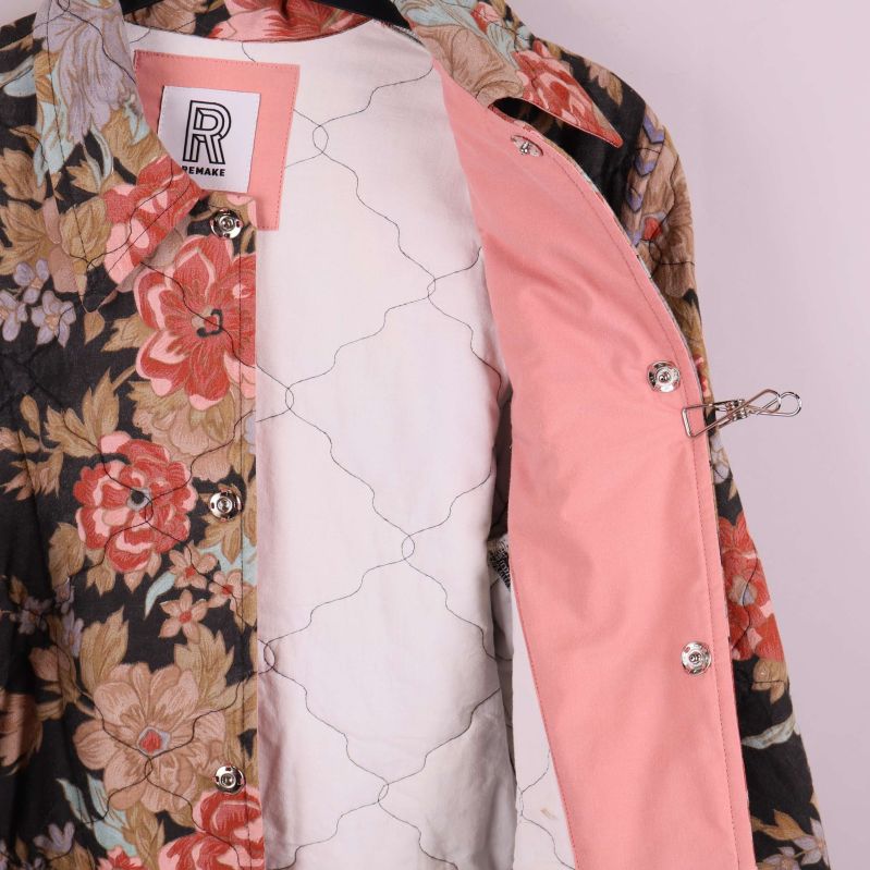 Insida av jacka med rosa foder och knäppning