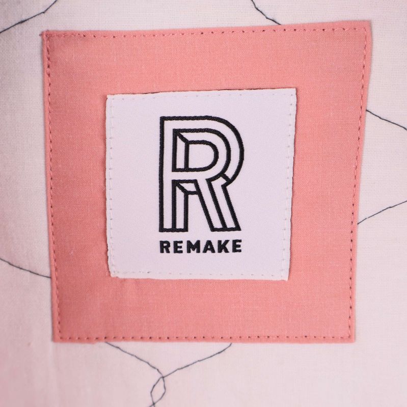 Remake-logga på rosa tygbit inuti jackan