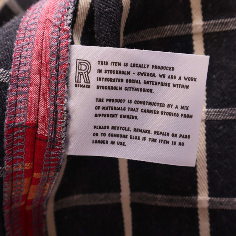 Vävd etikett med text om Remake-produktion i jackans foder