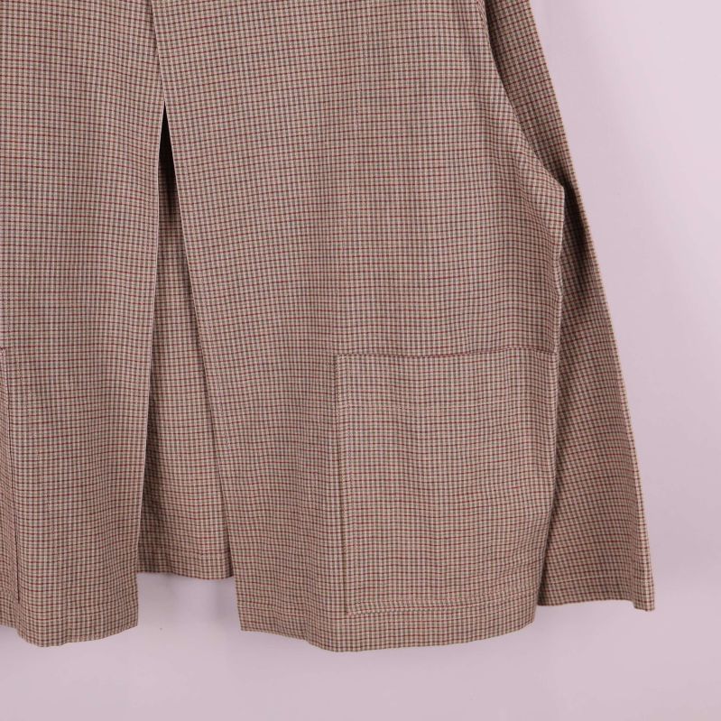 Närbild på stora fickor på rutiga jackans framsida