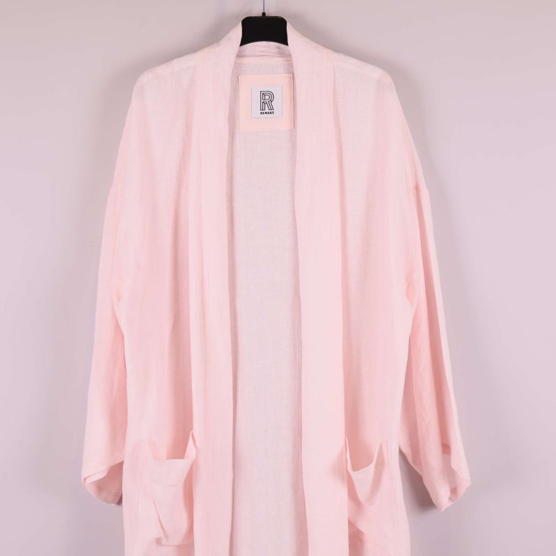 Överkropp och fickor på ljusrosa kimono i närbild