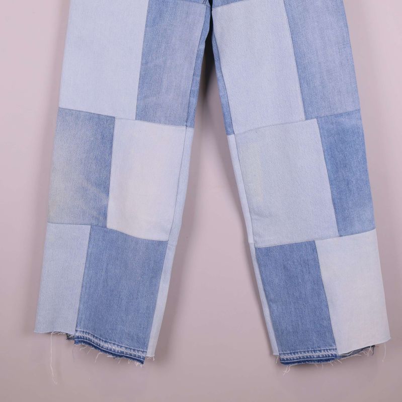 Närbild av jeansens ben med ljusa och mörka lappar