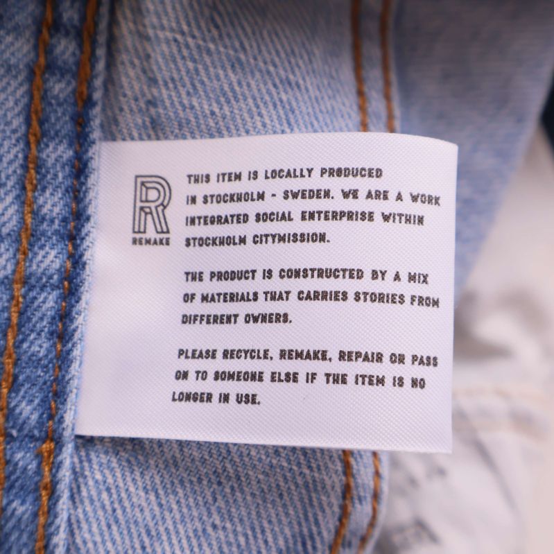 Informationsetikett om jeansen från Remake STHLM