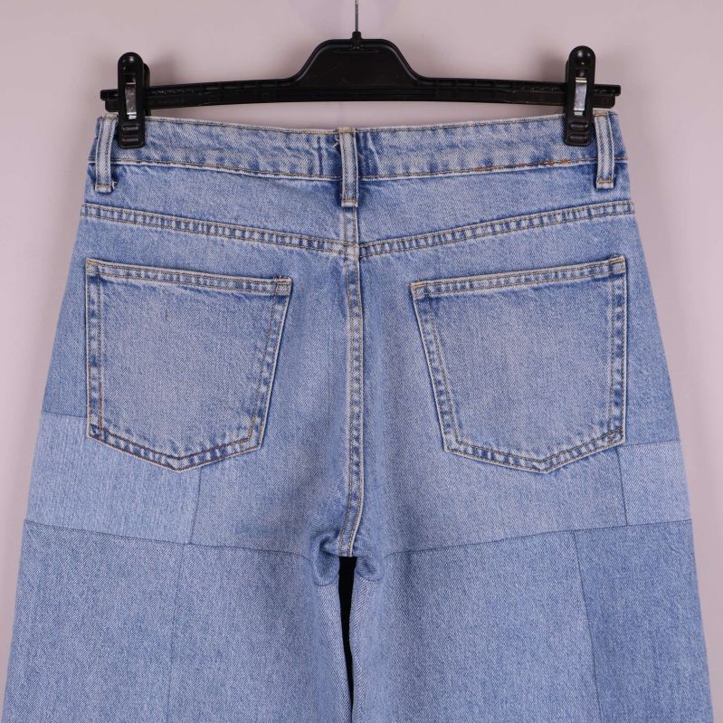 Närbild bakfickor och linning på patchwork-jeans