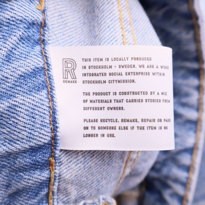 Informationsetikett inuti jeansen på engelska