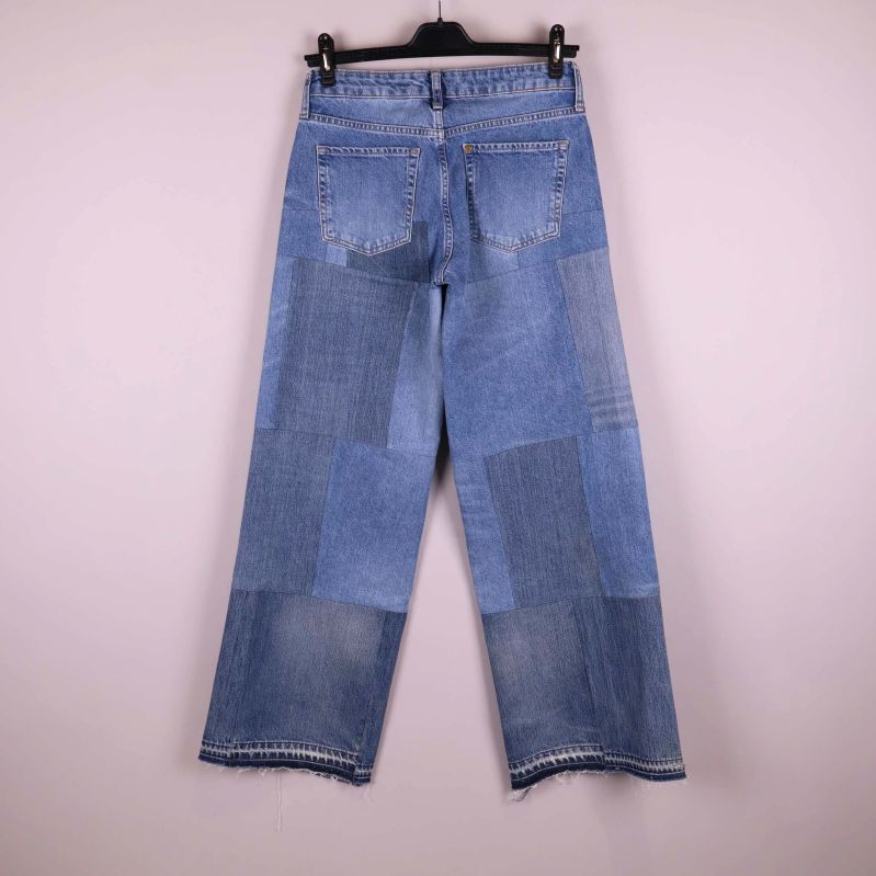 Baksida av patchwork jeans med bakfickor