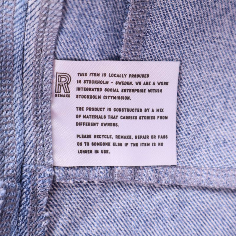 Etikett med engelska produktions- och materialuppgifter insydd i jackan