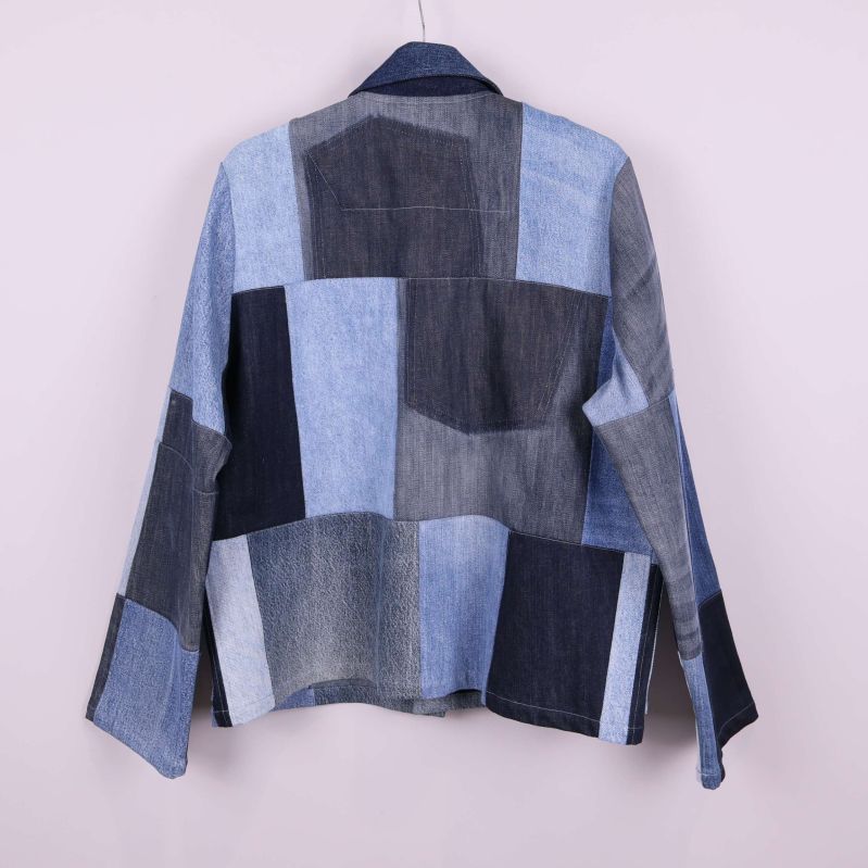 Baksida av denimjacka med mörk- och ljusblå lappar