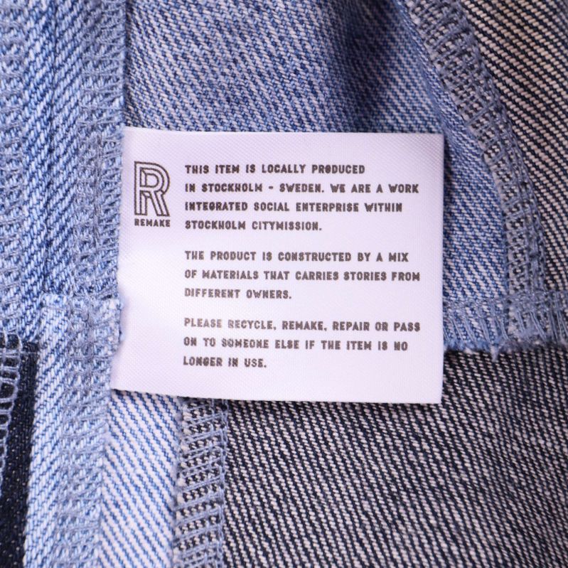 Tygetikett inuti jackan med engelsk text om produkten