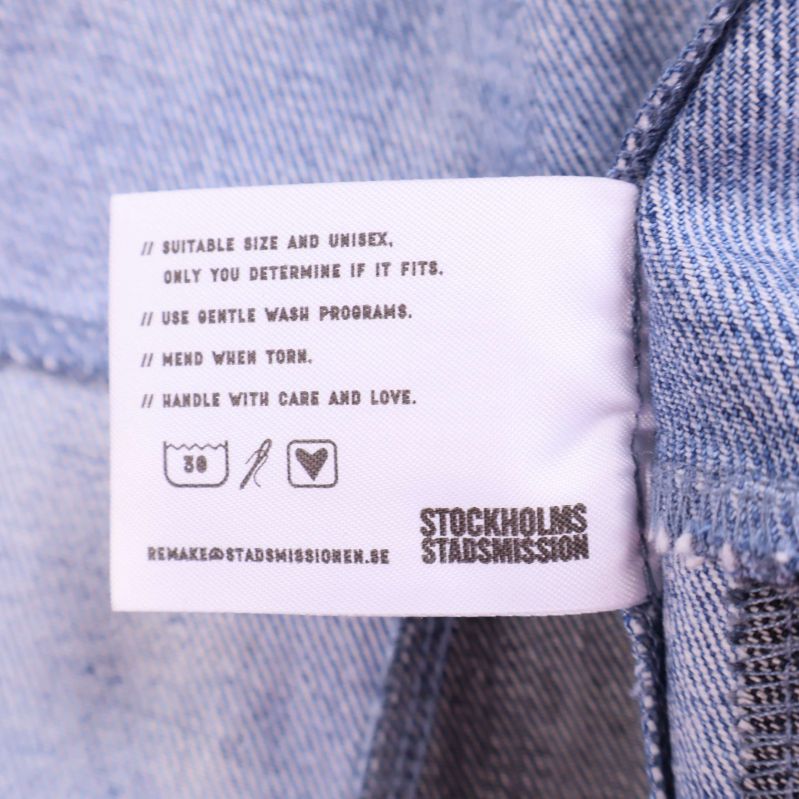 Tvättrådsetikett med symboler och Stockholms Stadsmission logga