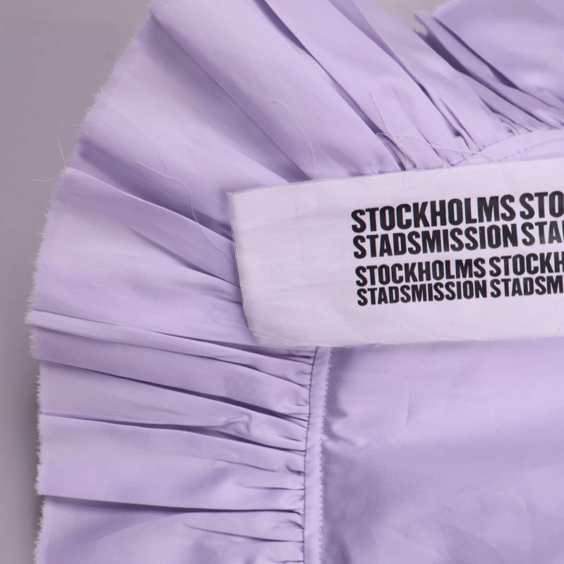 Närbild på sytt textband Stockholms Stadsmission