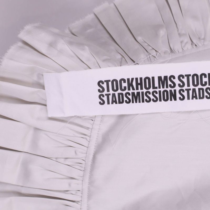 Textband med svart tryck på vit tygväska