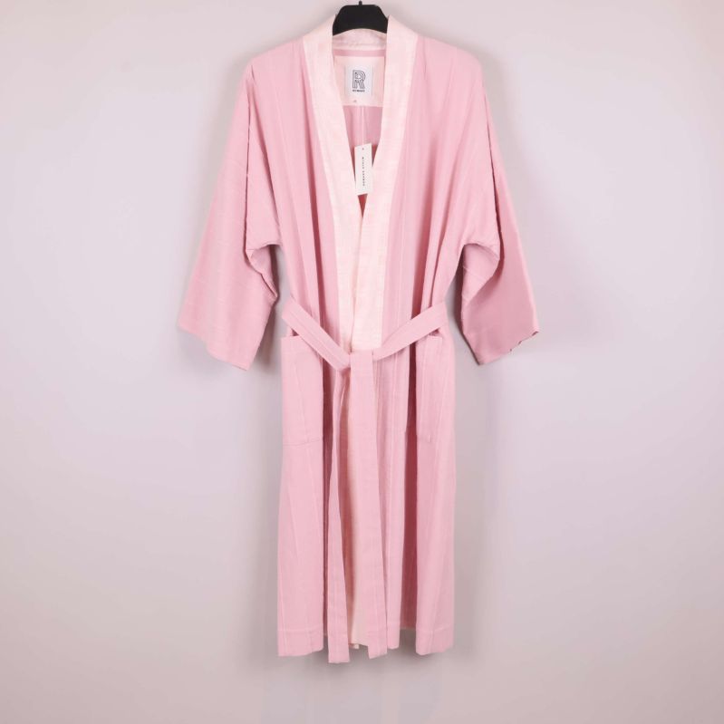 Rosa kimono med bälte hängande på galge