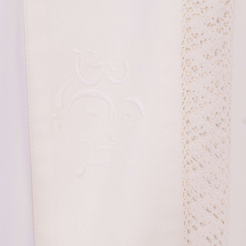 Detaljbild på broderi och spets på skjortans framsida