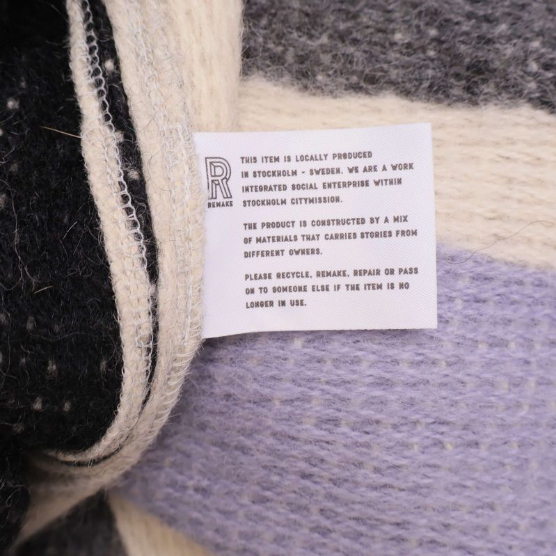 Informationslapp om materialmix och återbruk på cardigan