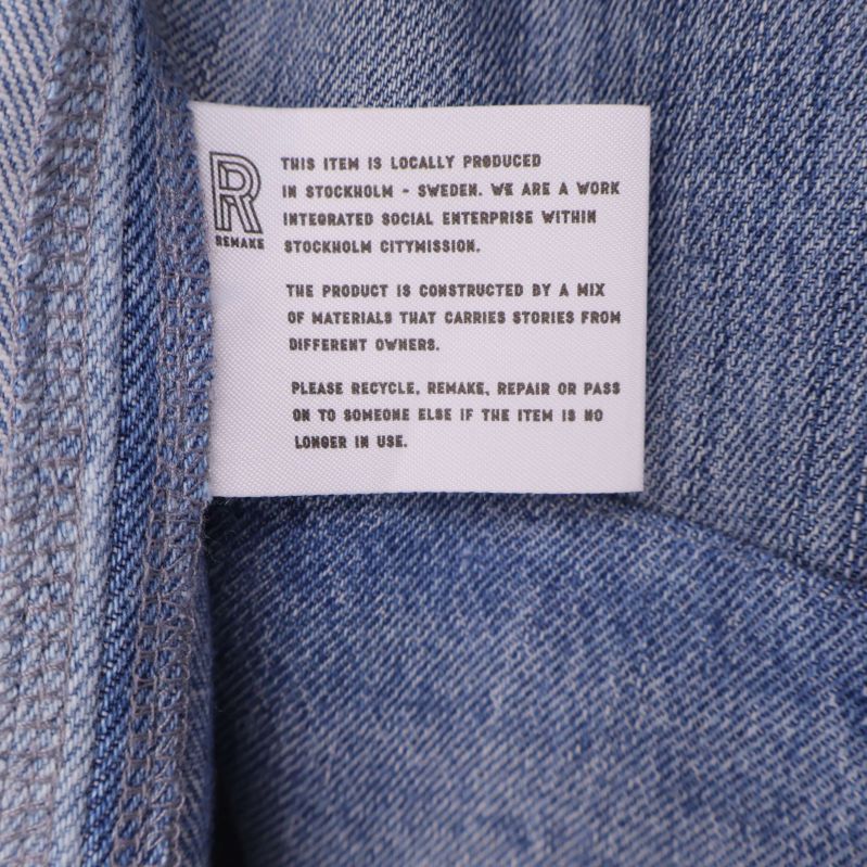 Tvättrådsetikett med text och symboler på denim