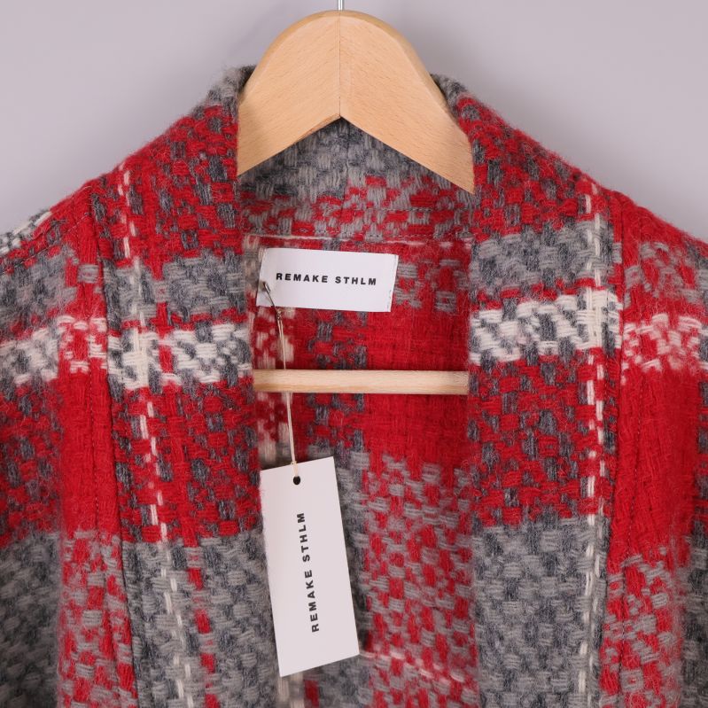 Närbild på etikett och hängare i rutig cardigan
