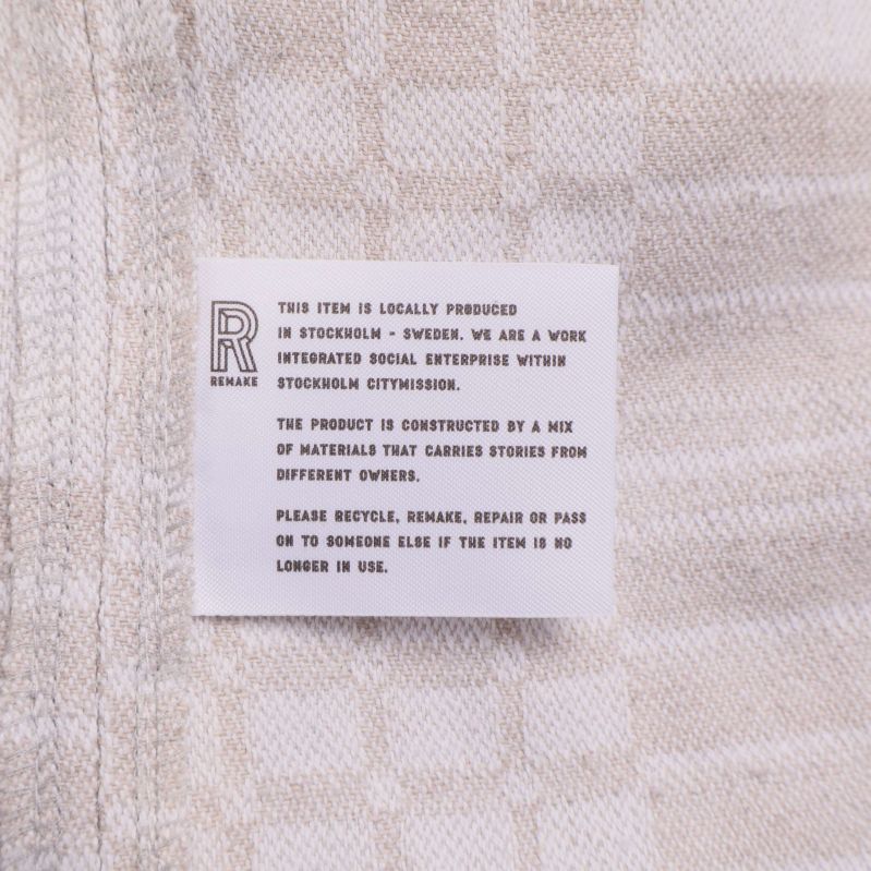 Detalj på tygmärke med engelsk text om produkten