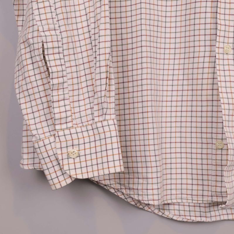 Detalj av skjortans ärmslut och rutigt tyg