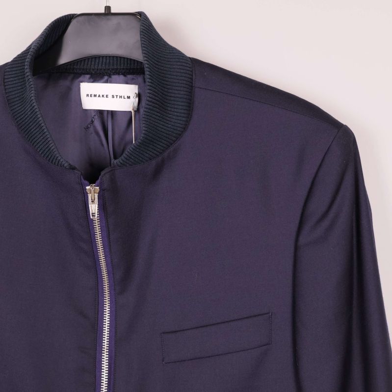 Detaljbild på bröstficka och dragkedja på kavaj