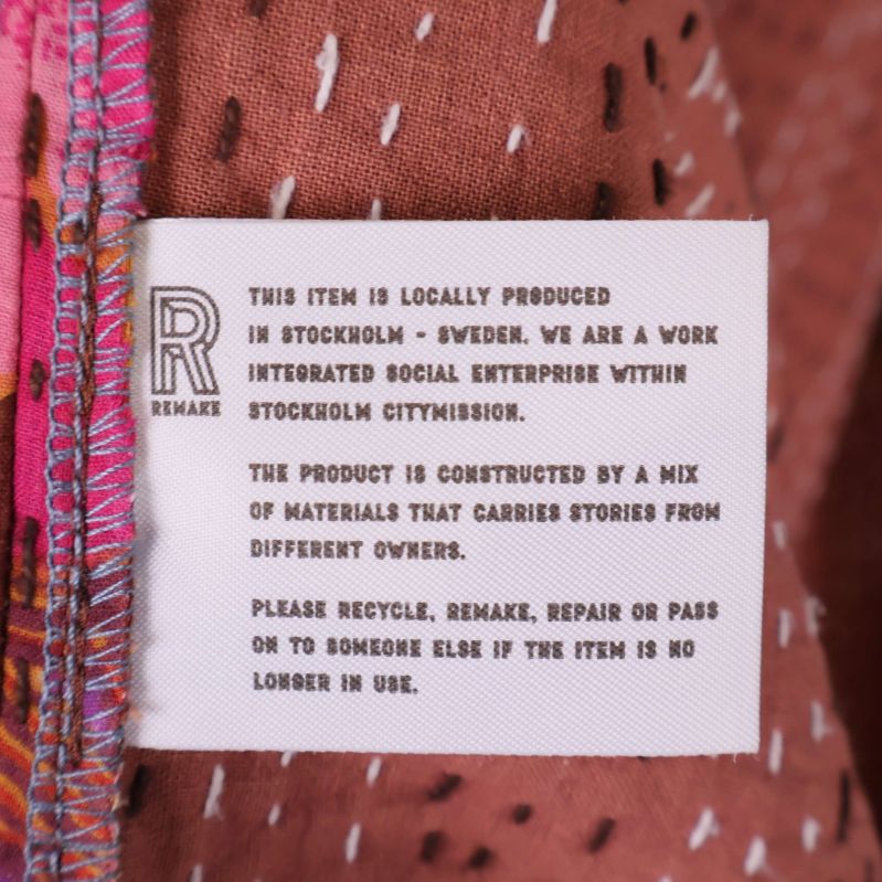 Tygetikett med engelsk text om lokal produktion