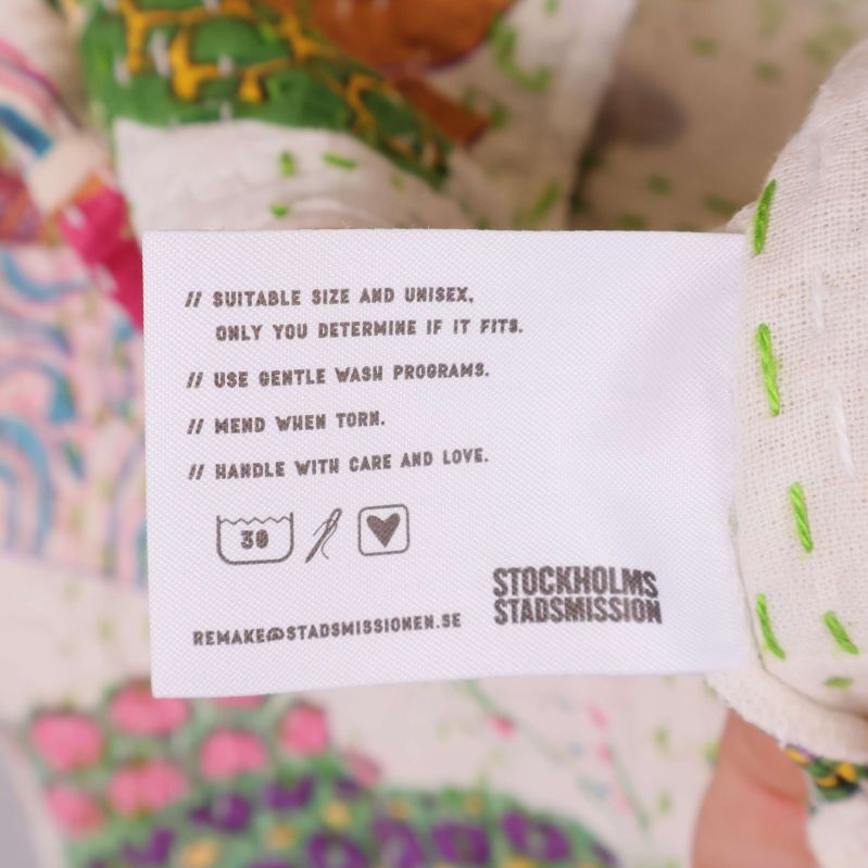 Tvättrådsetikett med skötselinstruktioner och symboler