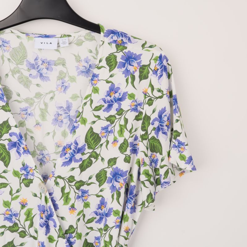 Närbild på blommigt mönster och halsringning